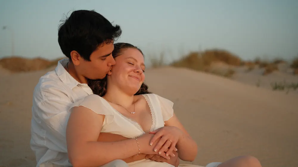 Couple cuddling in the dunes of El Palmar