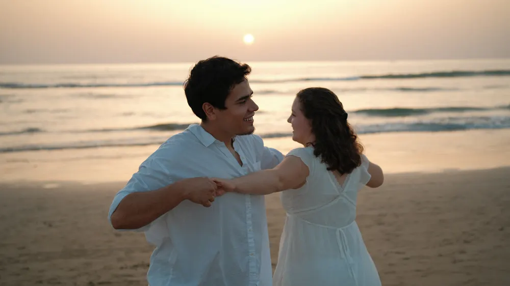 Couple at the water's edge at golden hour