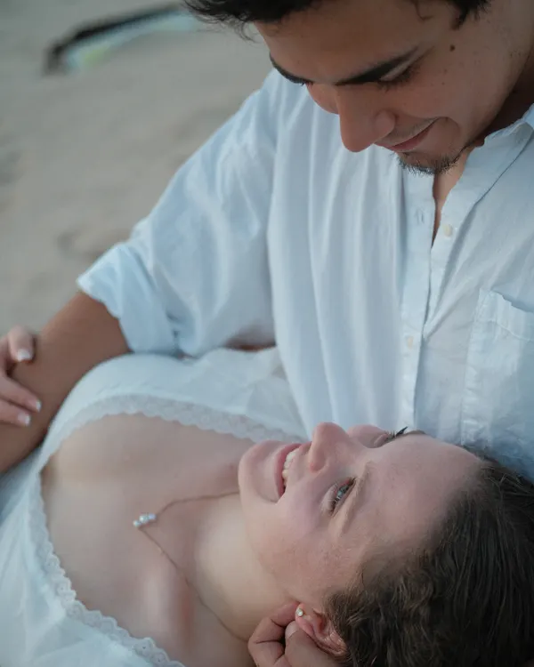 Couple lying in the sand at sunset