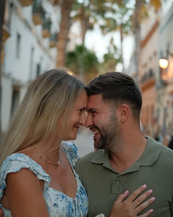 Couple embracing in a palm-lined street in Cádiz