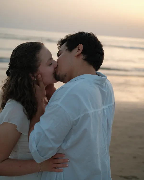Couple kissing on the beach at sunset