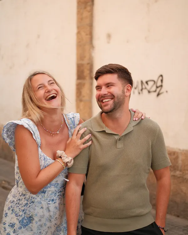 Couple laughing in front of an old wall in Cádiz